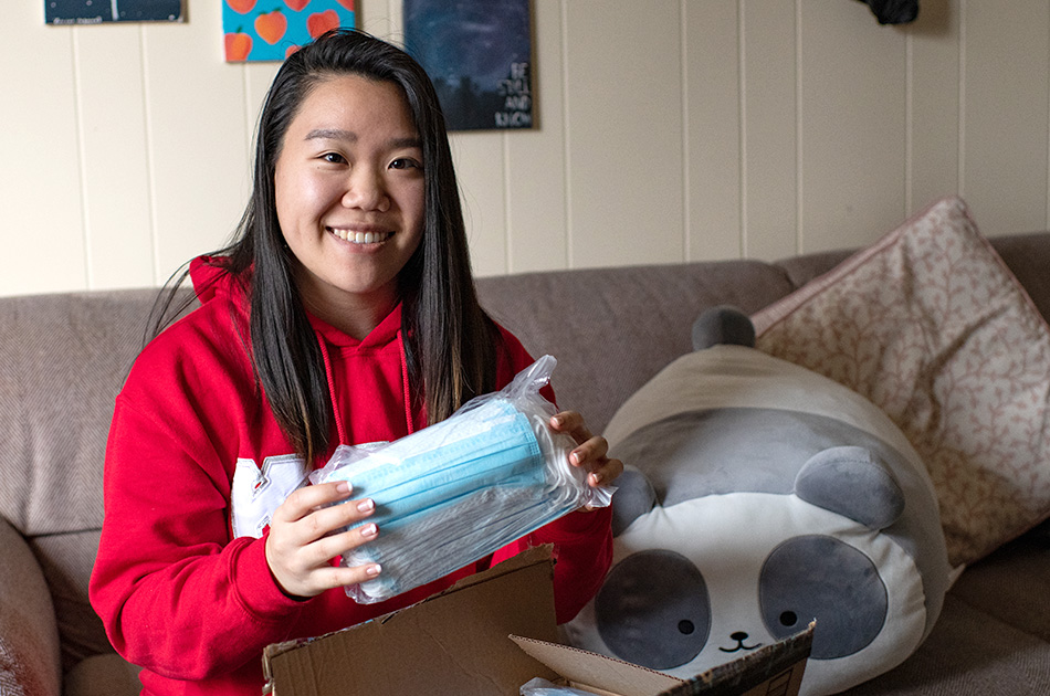 Smiling woman hold a package of surgical masks
