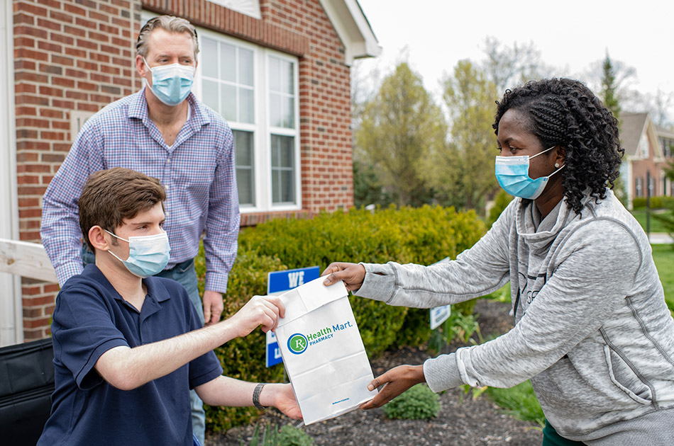 Woman delivering medication to a man and his son