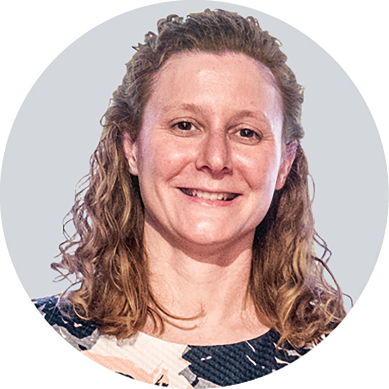 Kristin Stover smiles in this headshot taken at the ceremony. She has brown eyes, curly hair and a patterned dress.