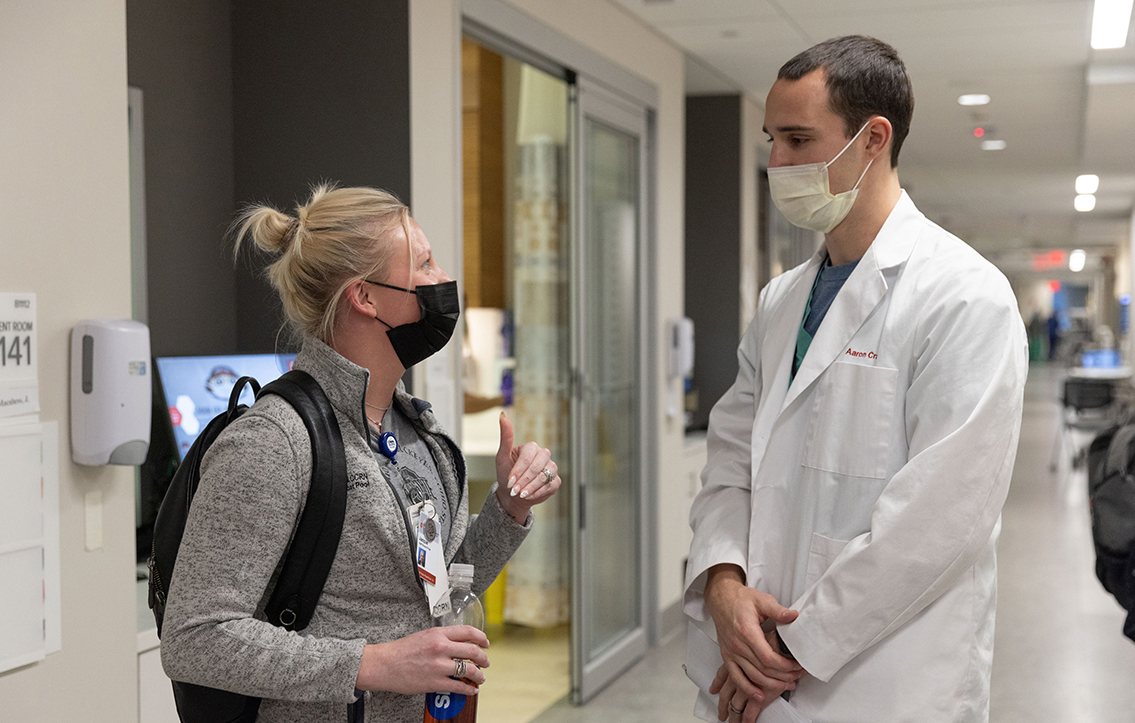 Aaron Craft talks to a nurse in a hallway of the Wexner Medical Center