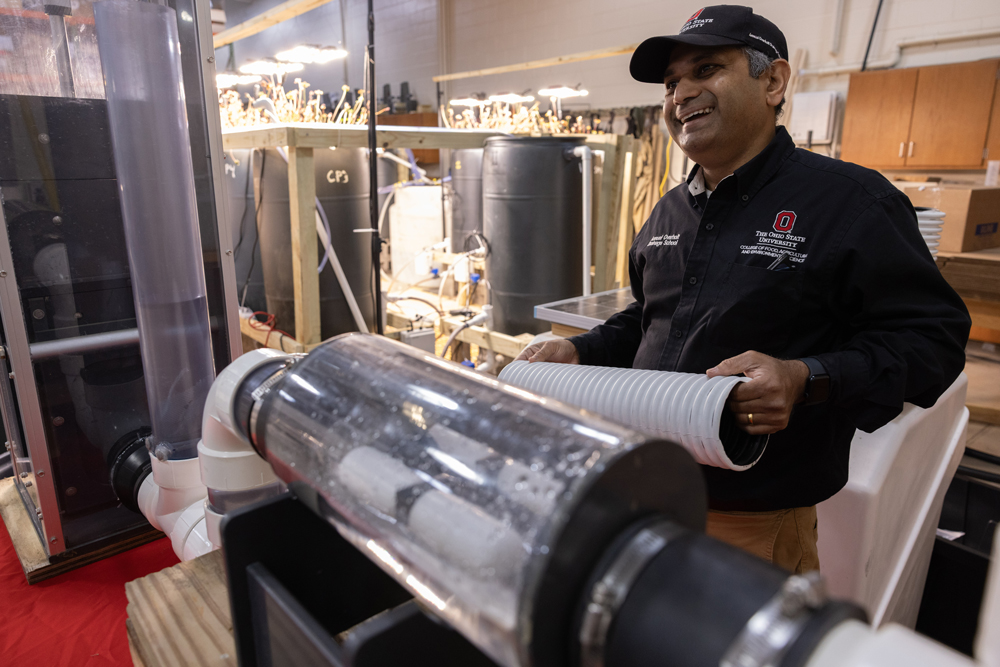 Shedekar laughs as he demonstrates a machine that controls moisture levels in farm fields.