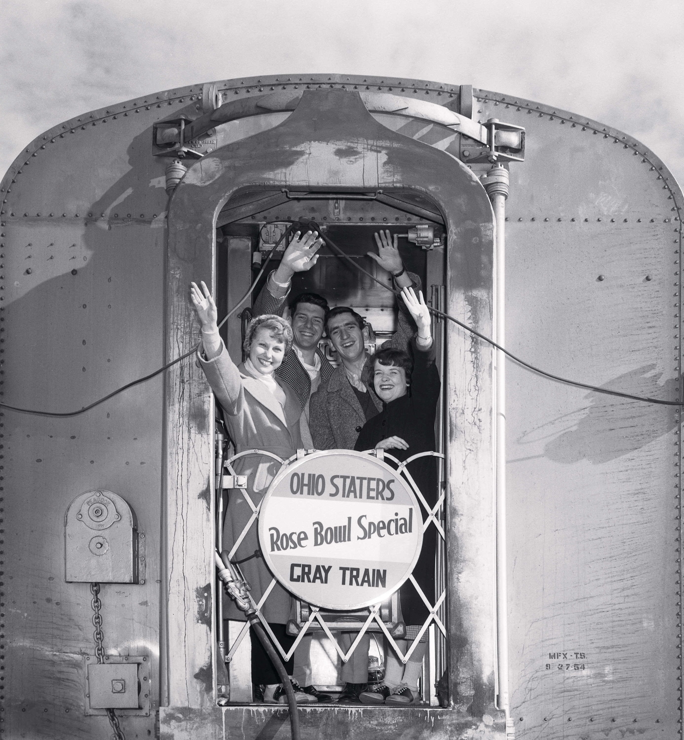 People waving from the back of a train