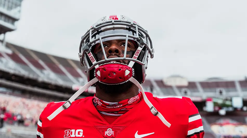 Jaxon Smith-Njigba wearing his football uniform of a red jersey and gray helmet