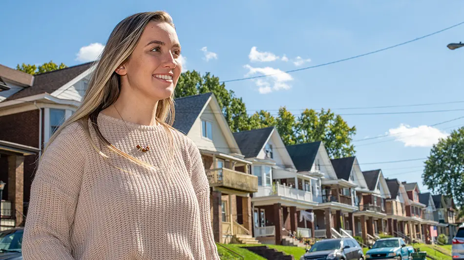 taylor standing in front of row of homes