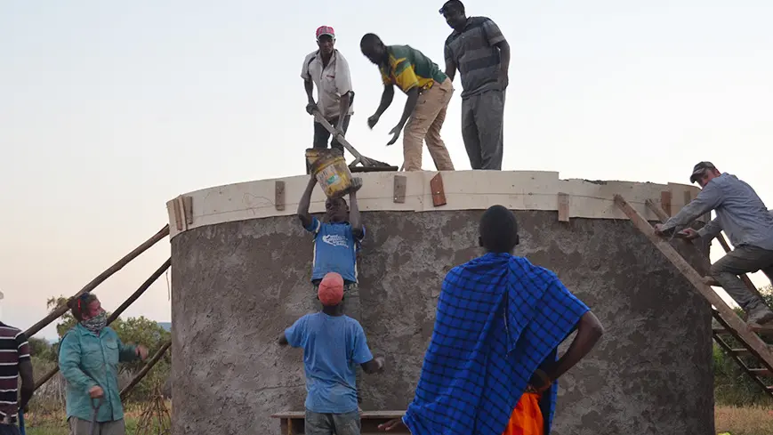 Ohio State students and community members from Tanzania install the roof of a rain-water harvesting tank