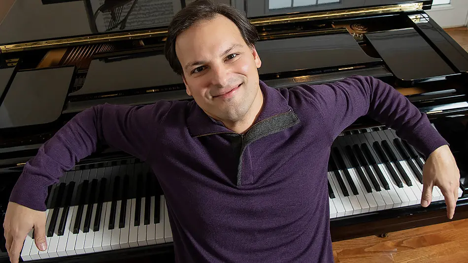pianist Orlay Alonso leaning back on a keyboard