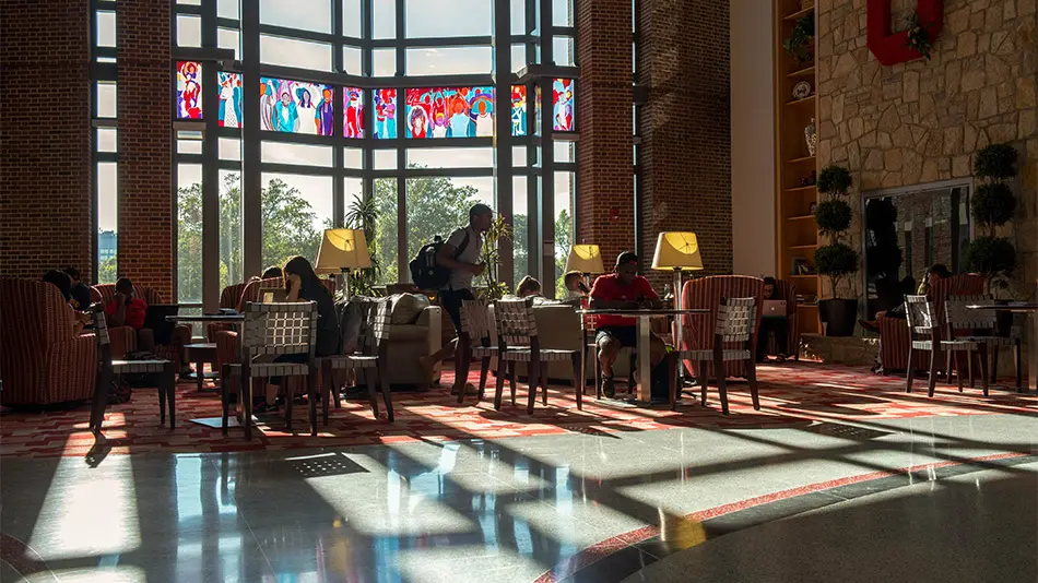 sun shining through the windows on students studying at the union