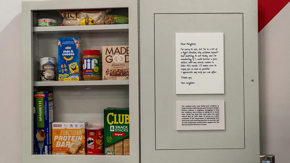 A wall hanging shows an open cabinet door with a note from Mr. Monda's college neighbor asking to borrow money. The Mondas keep the original note in their cabinet. This fake cabinet is stocked with cracks, peanut butter and macaroni and cheese.