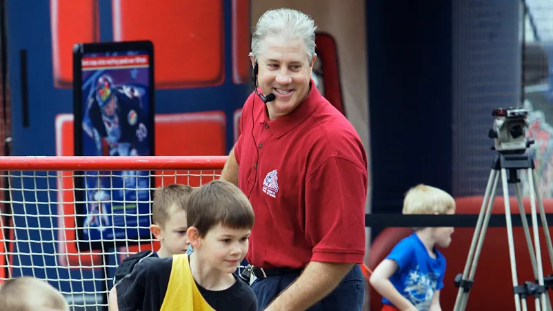 Bill Davidge smiles as he watches kids play hockey.