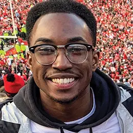 Headshot of Eyako Heh, a Black man with glasses, smiling