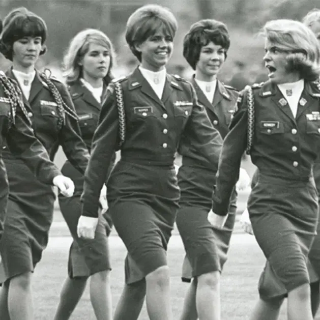 Black and white archival photo of a group of female cadets in uniform walking
