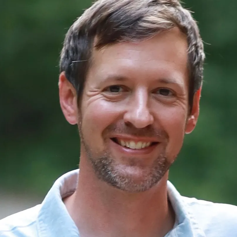 a smiling man looks directly at the camera