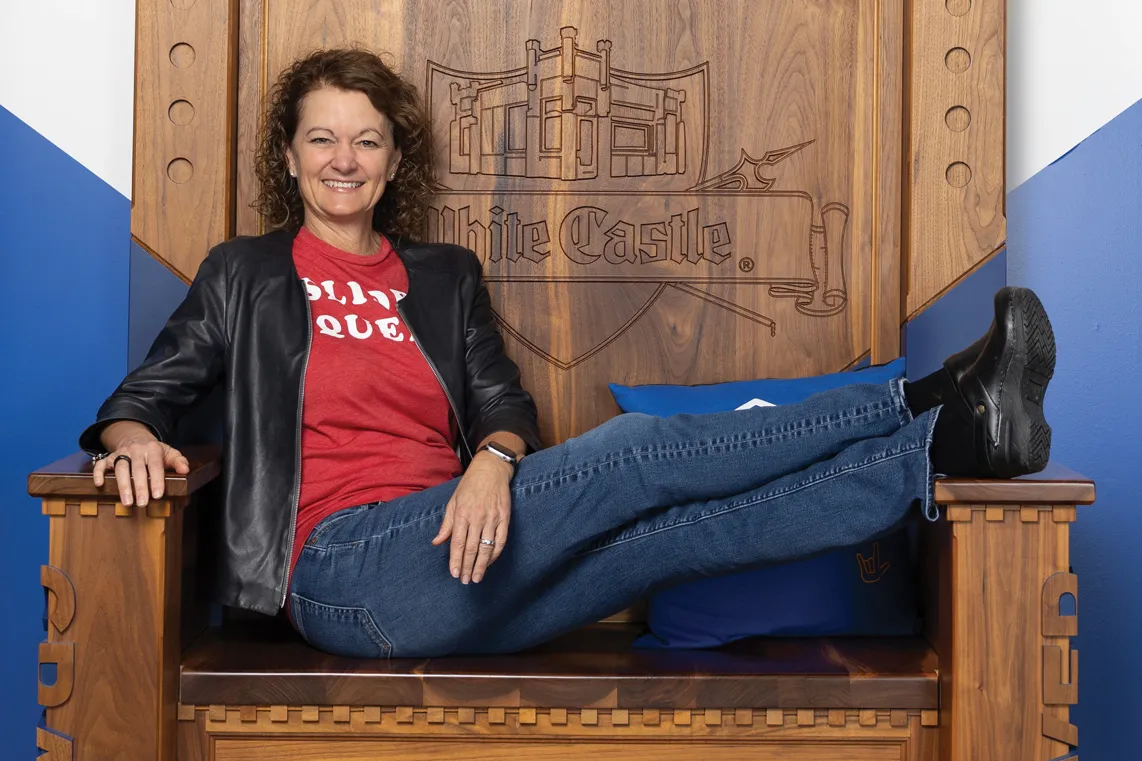 Lisa Ingram smiles as she lounges in a throne White Castle keeps in their Craver museum