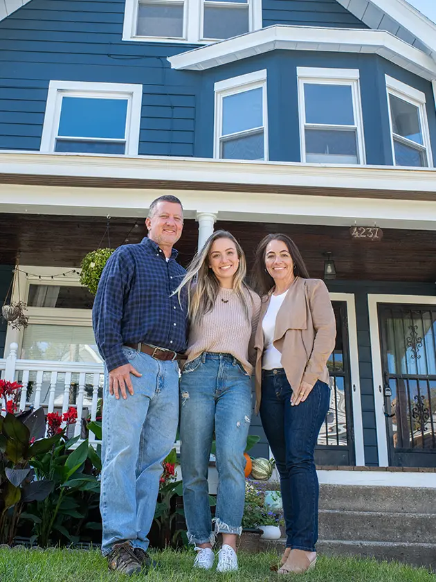 Marty, Taylor and Charity Gruenwald standing in front of home