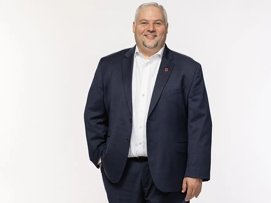 David Turkaleski is a white man with neatly shaped salt-and-pepper hair and goatee. Here he wears a suit with no tie and poses casually with one hand in a pocket. He's smiling like he is genuinely pleased to meet you.