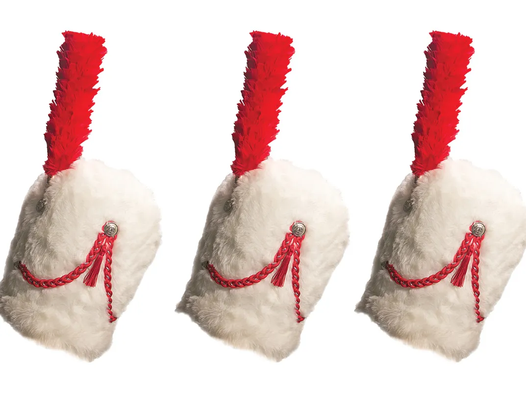 Three of the traditional tall, furry hat worn by TBDBITL drum majors